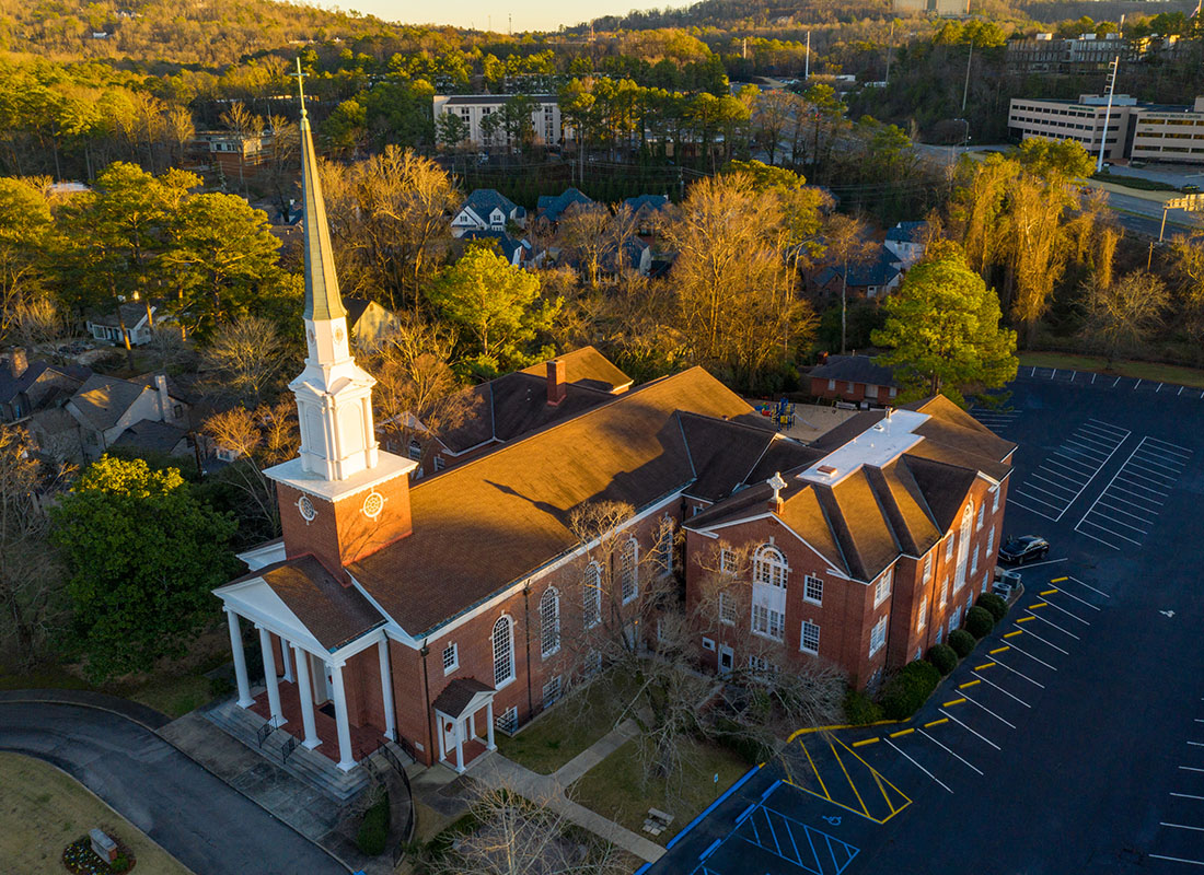 Insurance by Industry - Aerial View of a Church with an Empty Parking Lot Surrounded by Green Trees in Birmingham Alabama